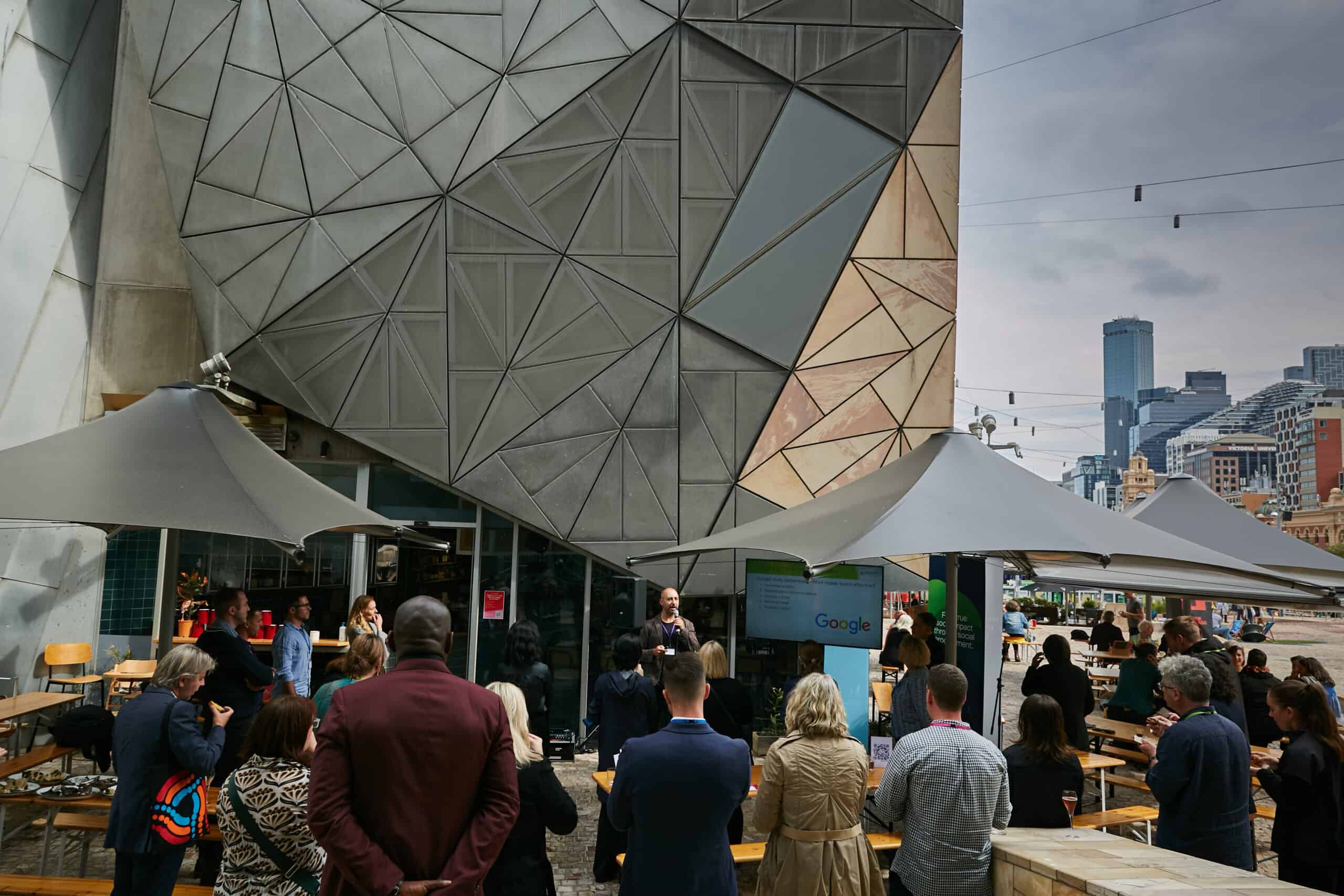 An crowd of people gathered in Melbourne's Federation Square, listening to a speaker at Jobsbank's first Meet The Suppliers event.